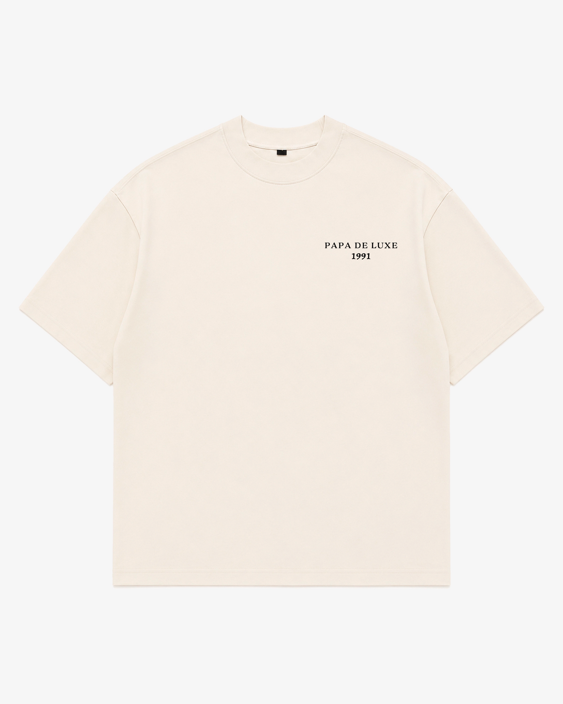 An off-white short-sleeve crewneck t-shirt with 'PAPA DE LUXE 1991' printed in black on the left chest, displayed flat against a light gray background.