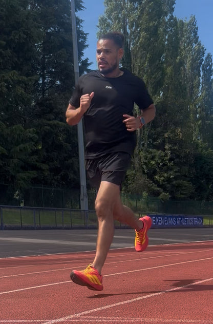 Man running on a track with trees in the background