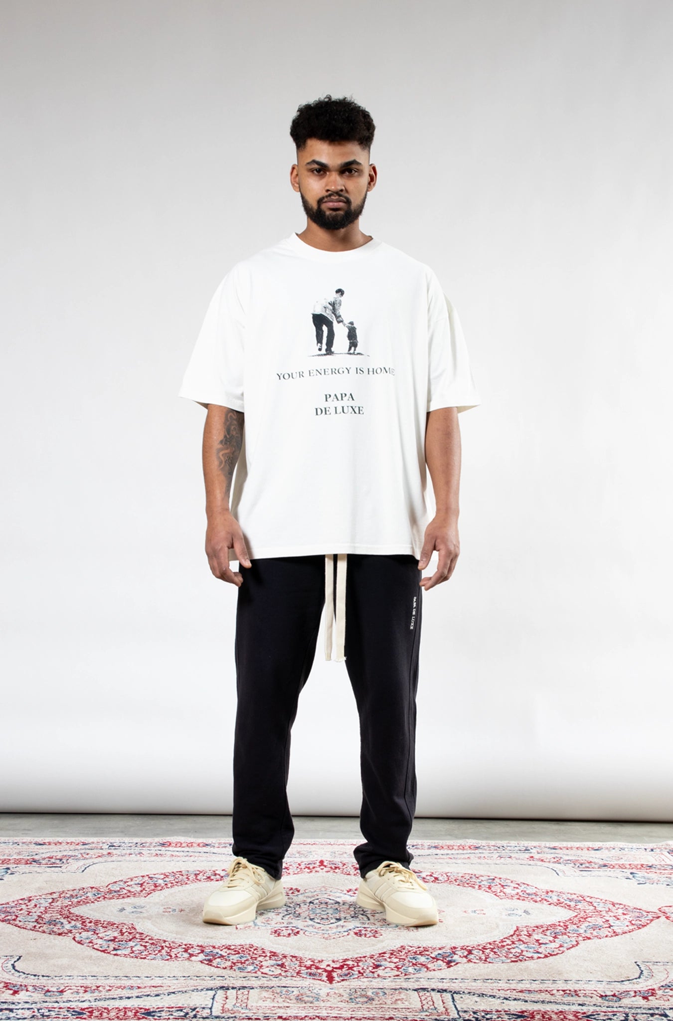 Man wearing Papa De Luxe 'Your Energy Is Home' white graphic T-shirt front view, relaxed oversized fit